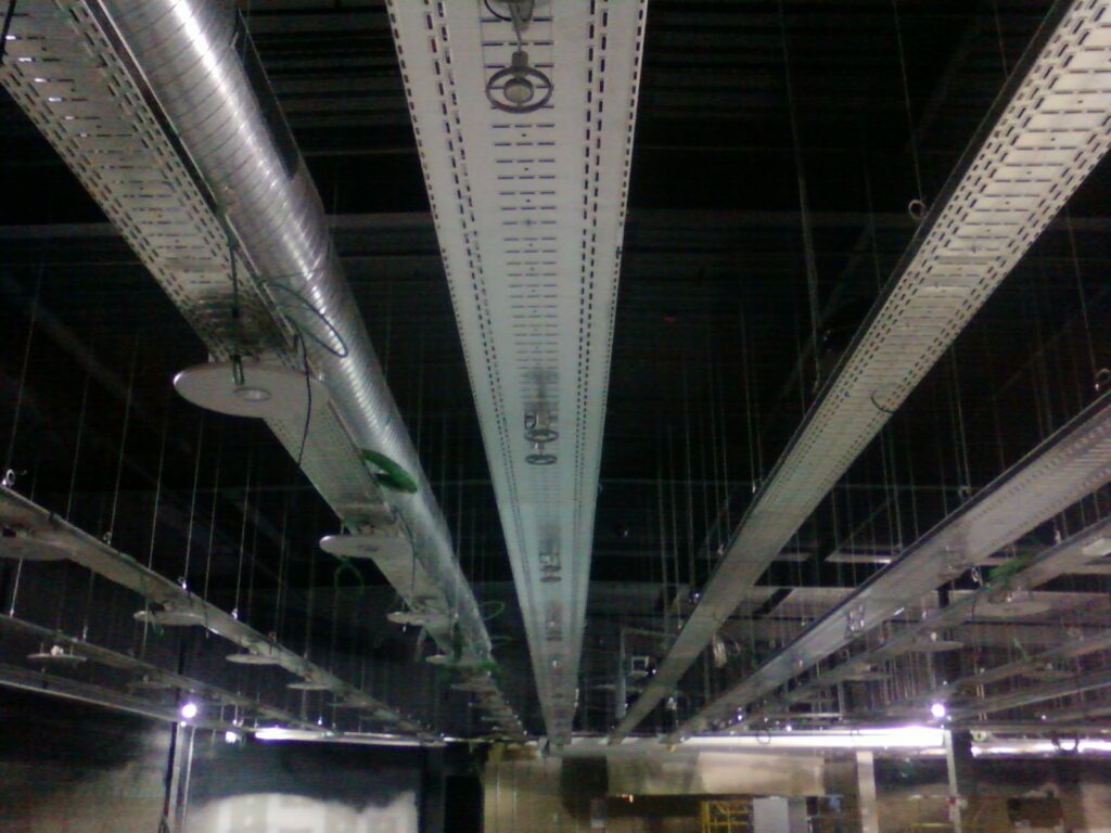 Bandejas portacables suspendidas junto a conductos en el techo de FNAC