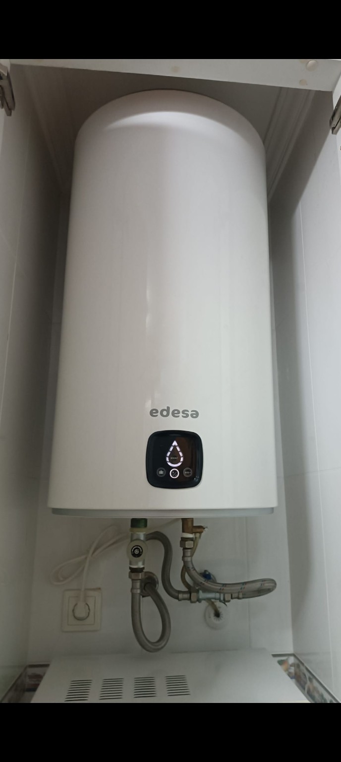 Termo eléctrico Edesa dentro de un hueco, con sus conexiones exteriores visibles