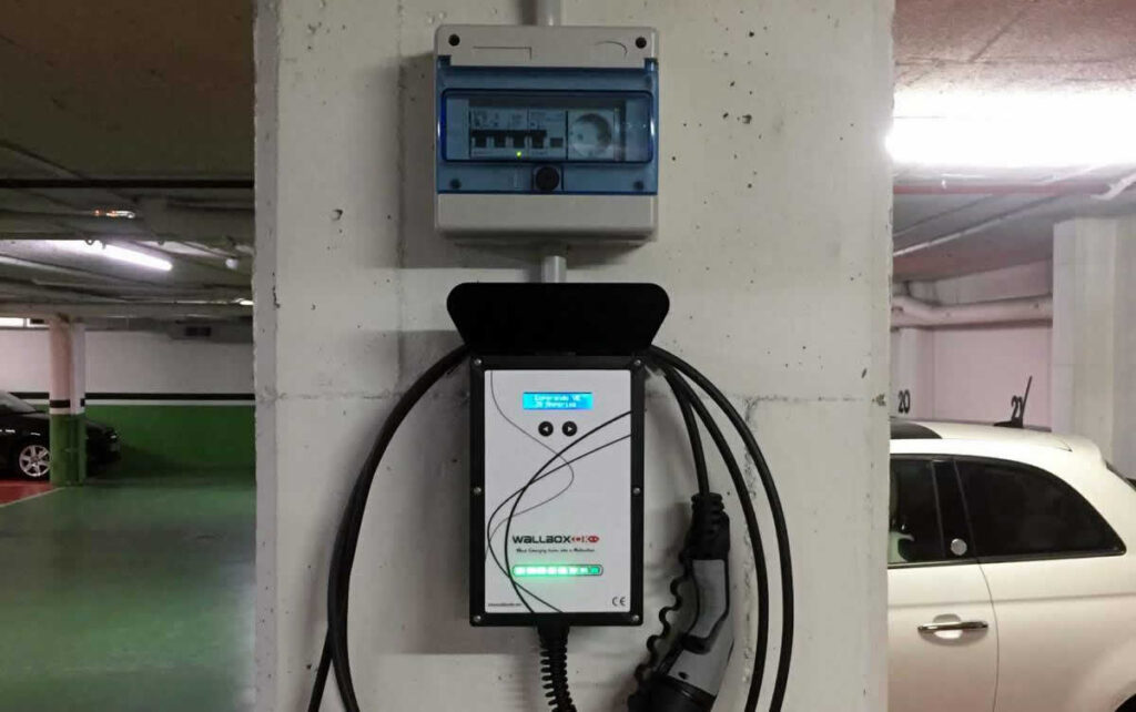 Cargador mural para vehículo eléctrico con su cuadro de protecciones en un garaje