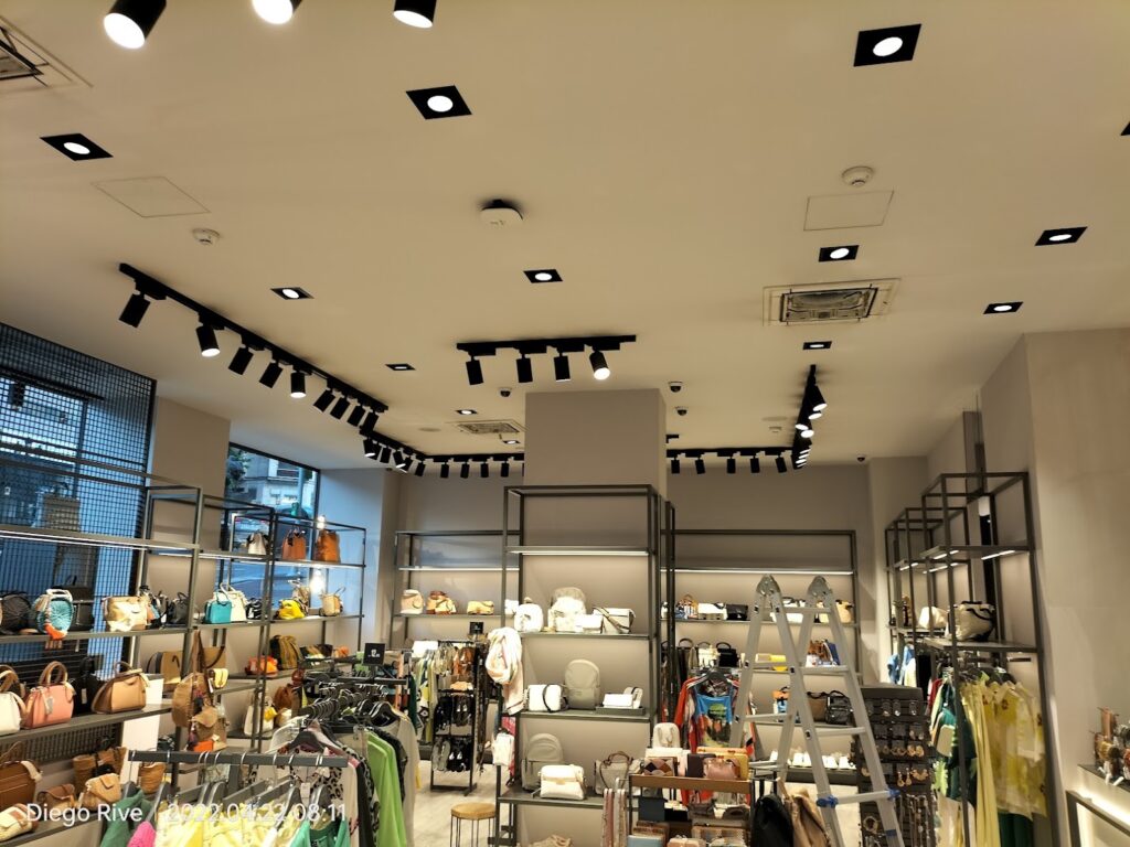 Vista del techo de una tienda con equipos de climatización y luminarias
