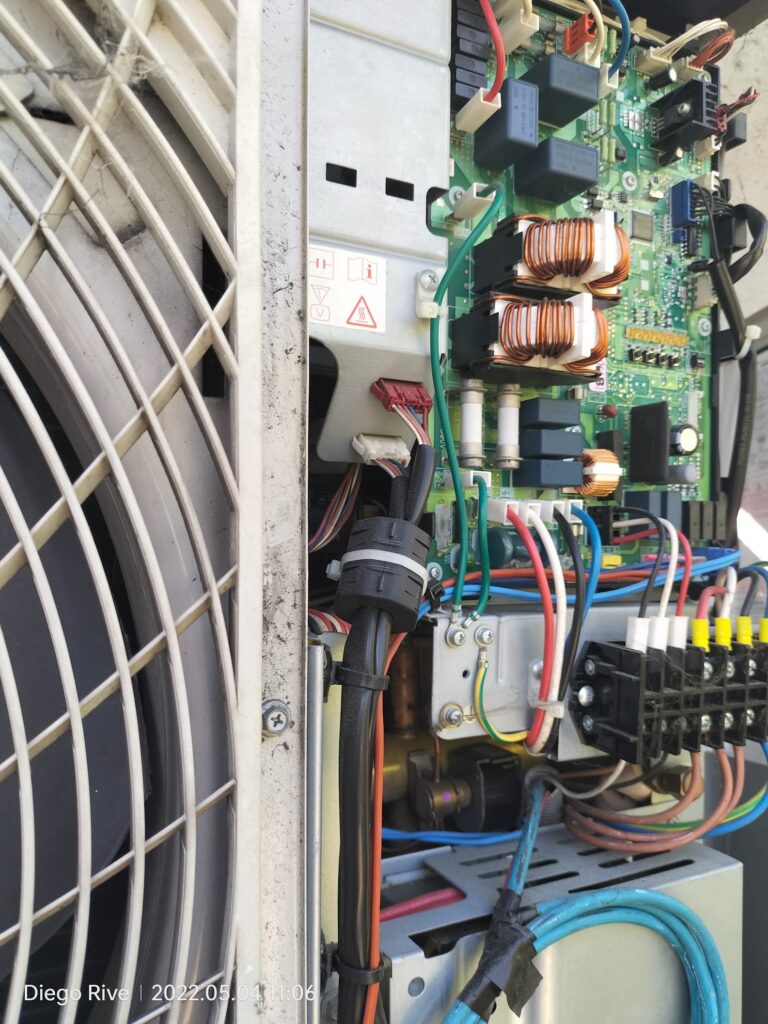 Placa electrónica y conexiones en el interior de una unidad de aire acondicionado