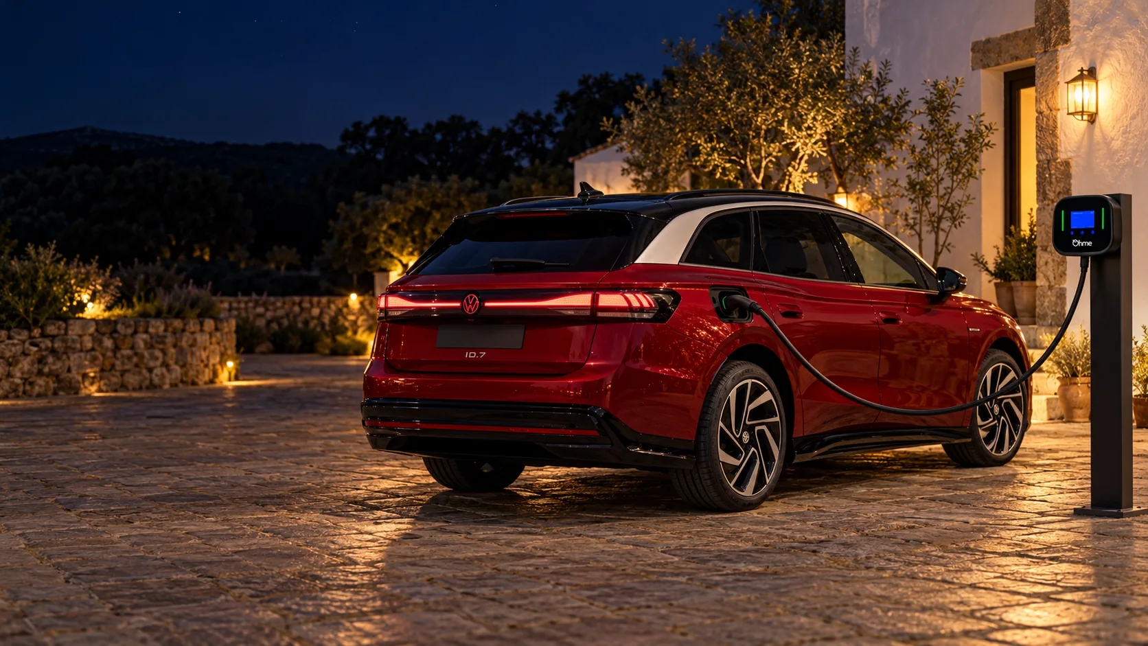 Imagen ilustrativa de un Volkswagen ID.7 Tourer rojo conectado a un Ohme Home Pro en un patio rural nocturno, con cargador en poste y cable elevado